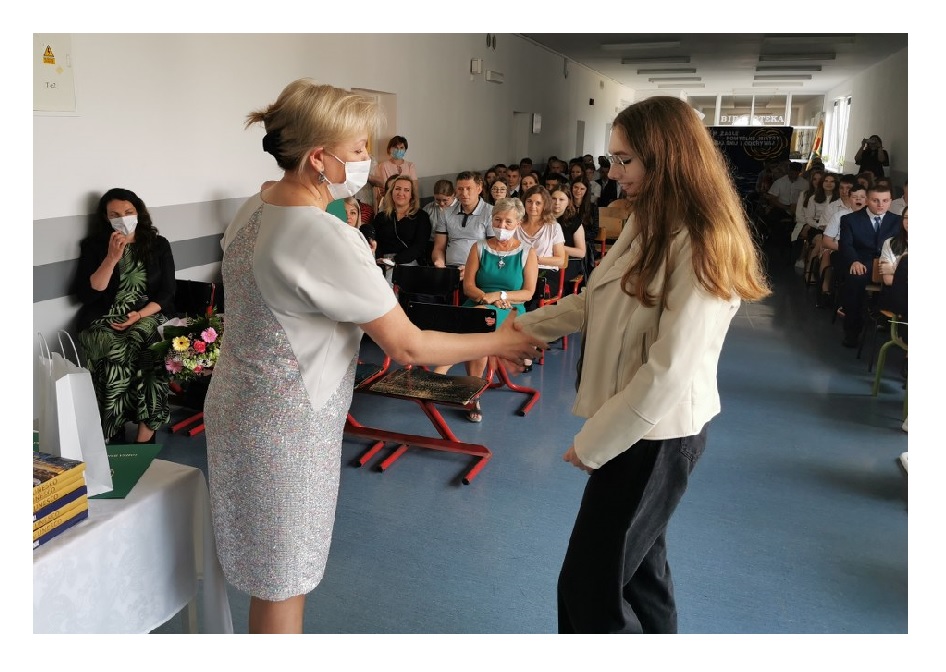 Dyrektor szkoły Małgorzata Krawczyk Figlarz składa gratulacje uczennicy 