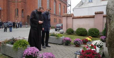 Przewodniczący RM Piotr Małek oraz ks. Proboszcz Adam Paź składają pod pomnikiem