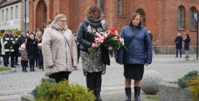 na zdjęciu Delegacja ŚDS "Słoneczko" składająca kwiaty pod pomnikiem